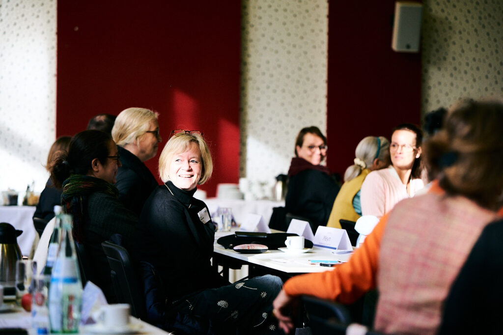 Teilnehmende der Veranstaltung an Tischen