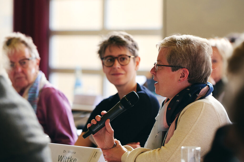 Teilnehmende der Veranstaltung spricht ins Mikrofon